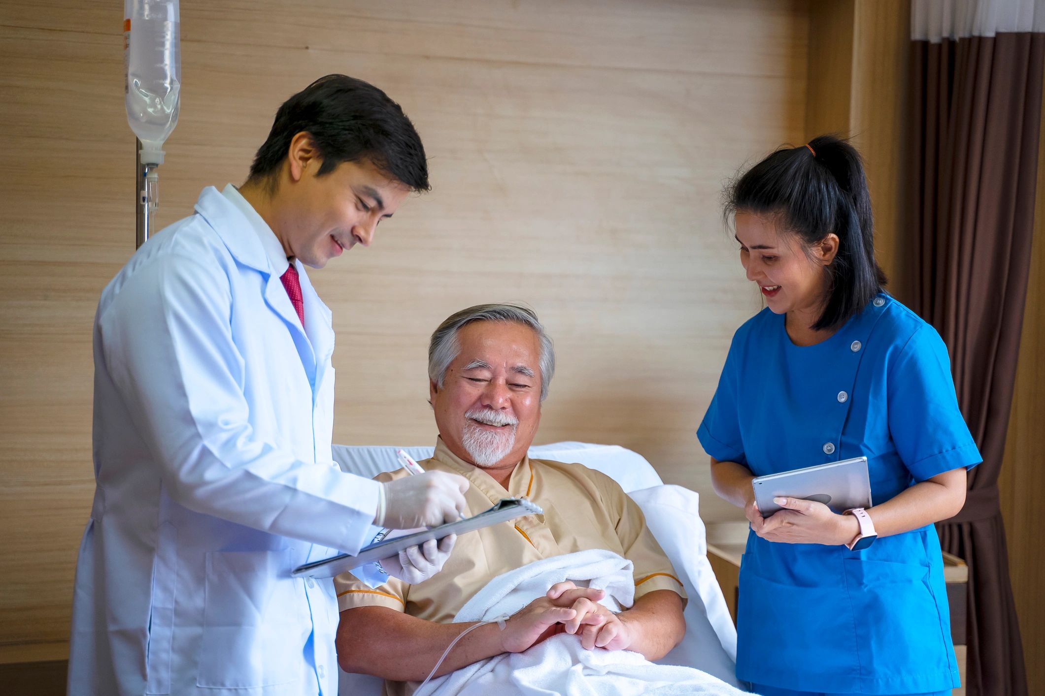 Healthcare staff supporting a patient in a hospital room